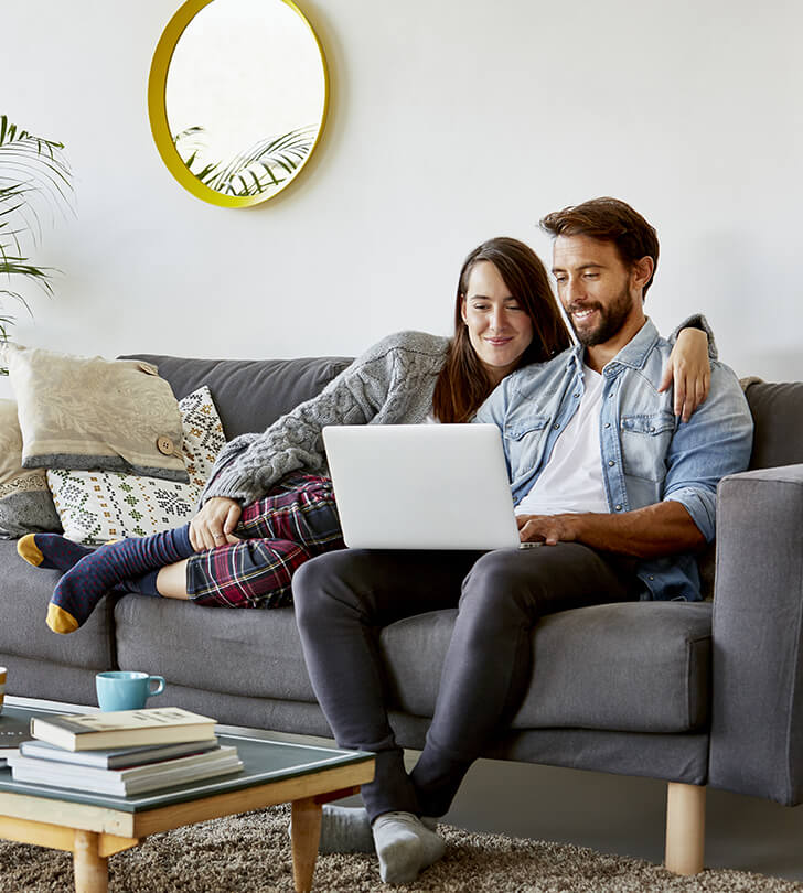 couple sharing a laptop in their living room